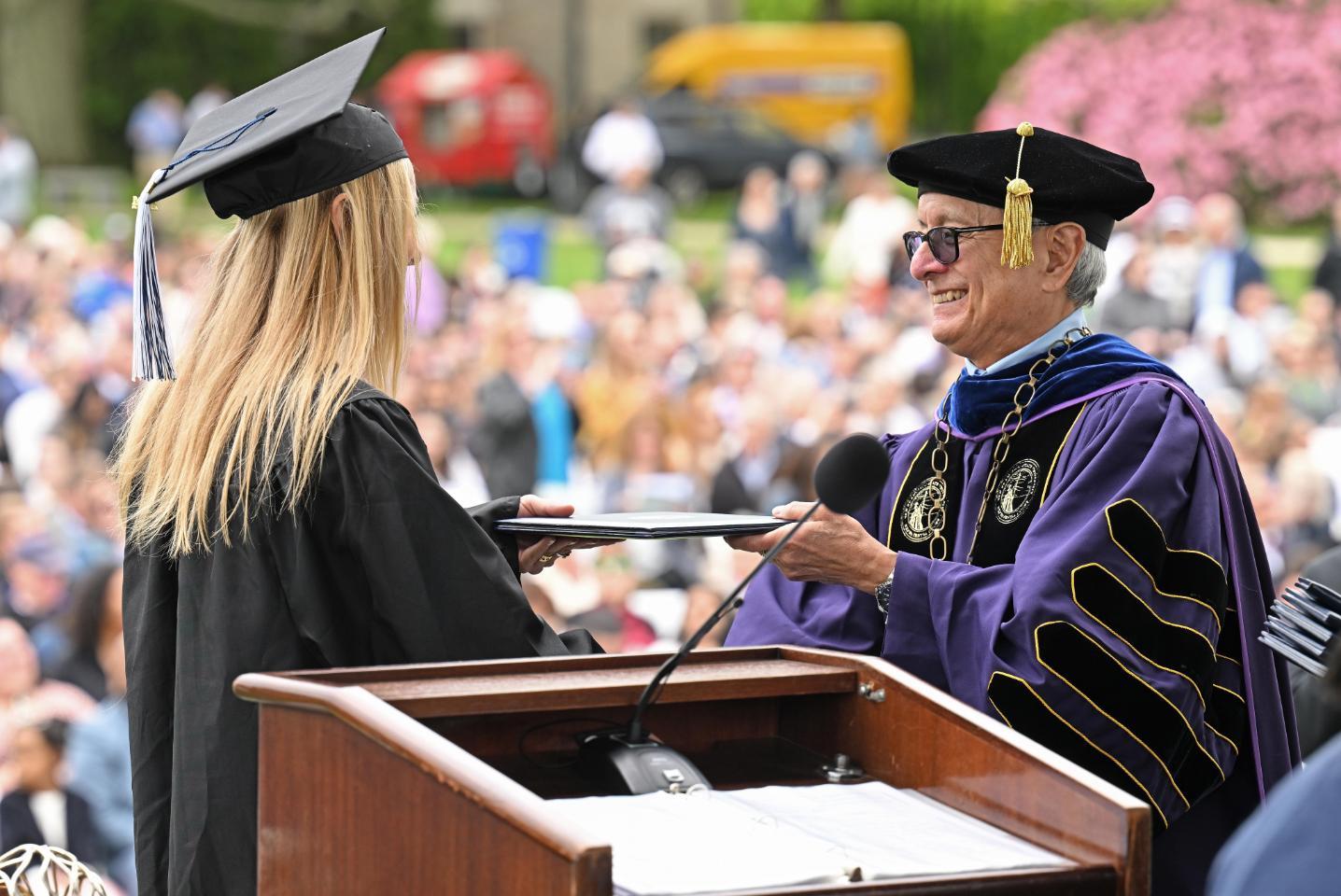 Student receiving diploma at Commencement 2024