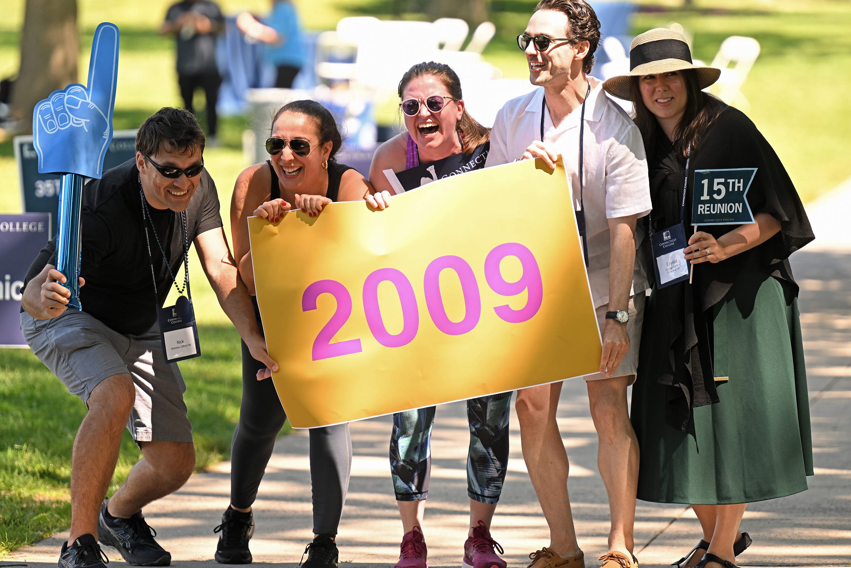 A group of college alumni holding a banner for the class of 2009 prepare to march in a parade