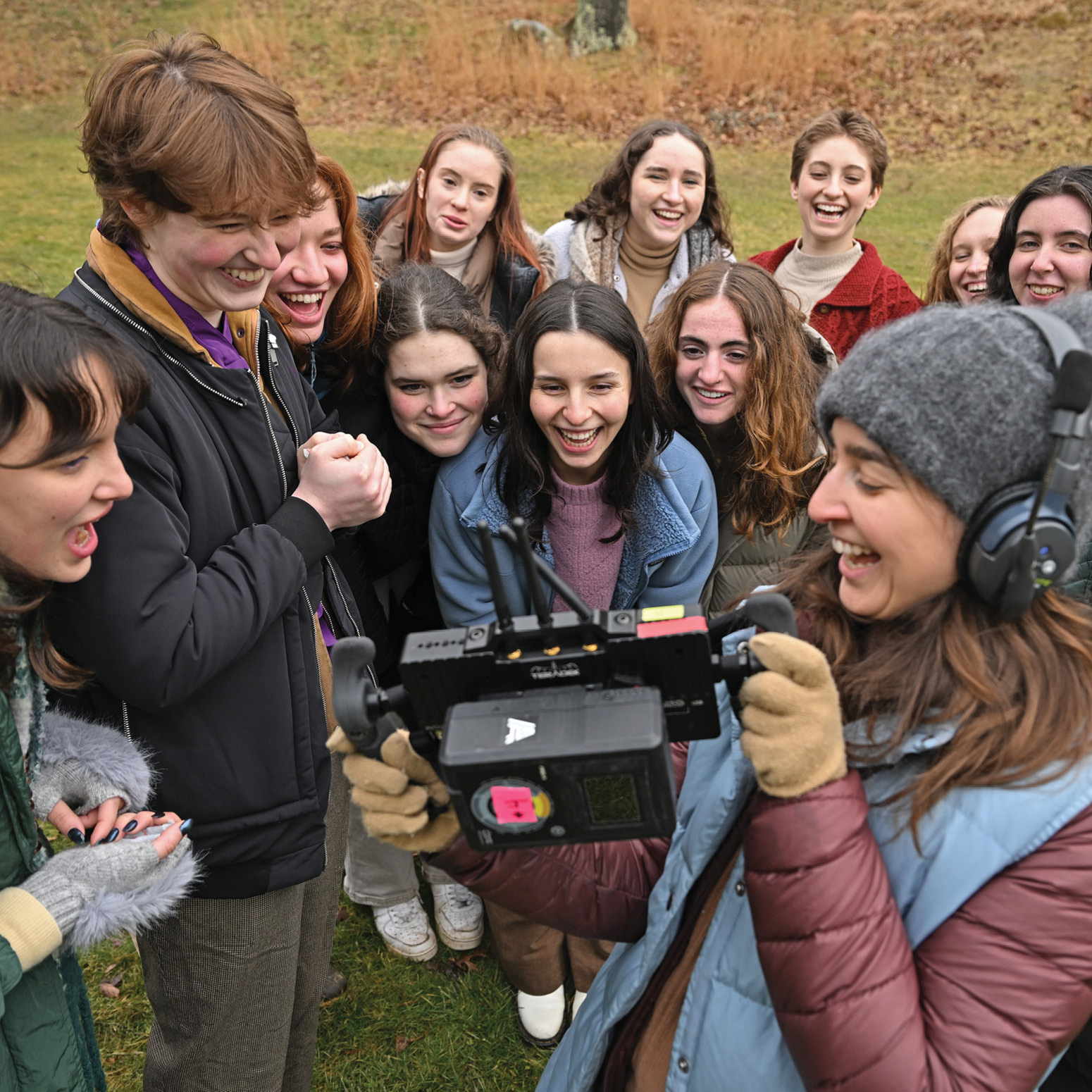 Dance students watch a video monitor of their performance in the Arboretum.