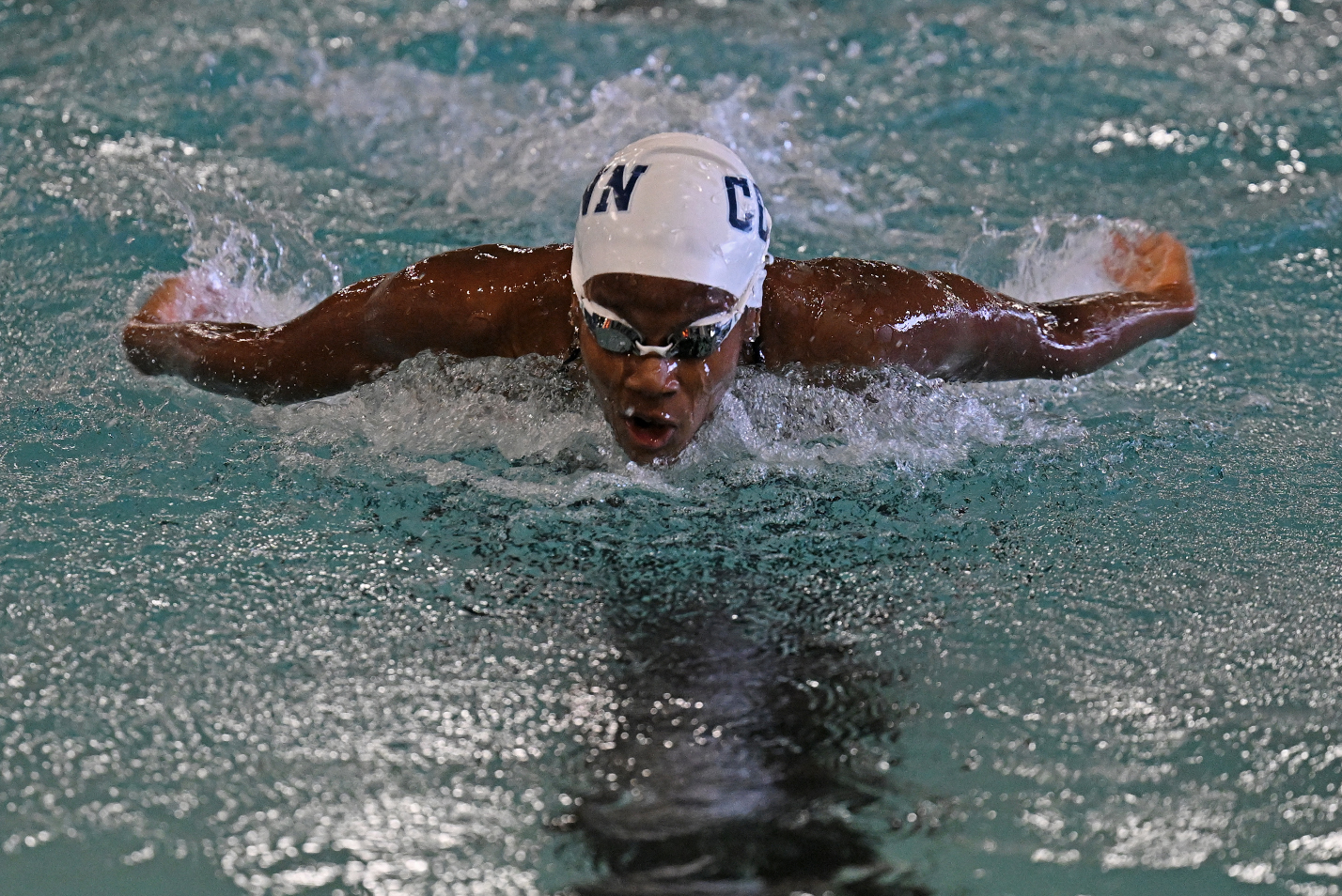 A swimmer competes in a butterfly stroke race.